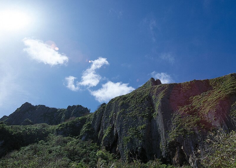 Sunlit cliff under blue sky