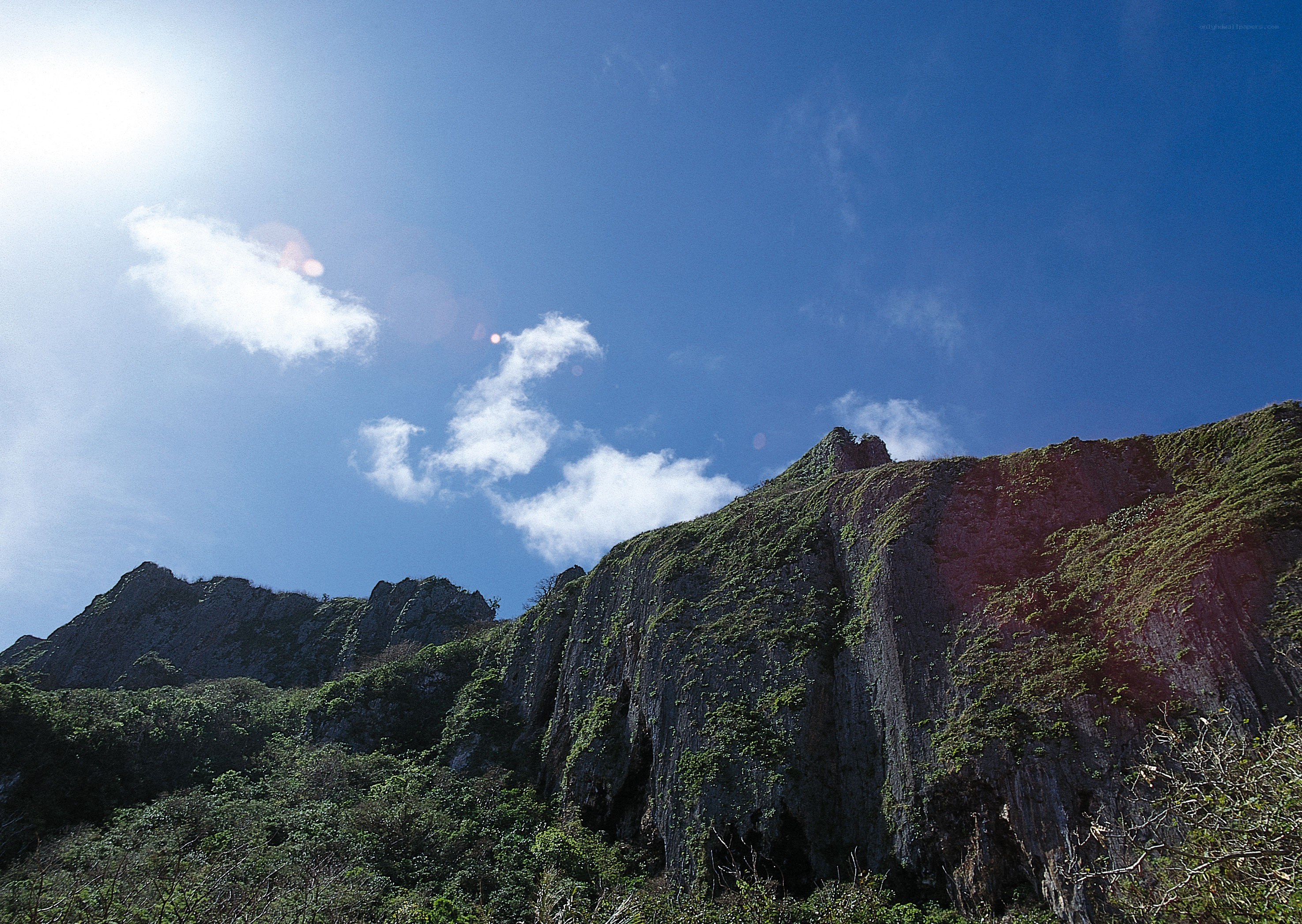 Sunlit cliff under blue sky