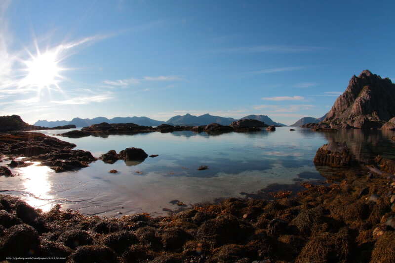 Sunlit coastal rocks and mountains