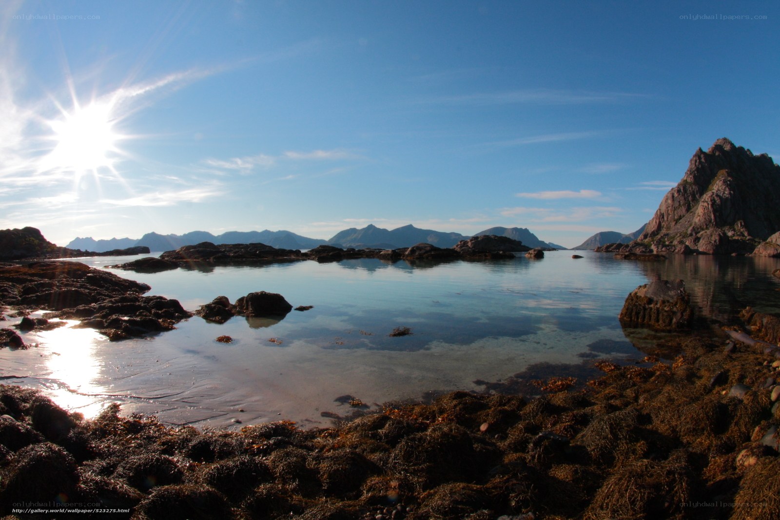 Sunlit coastal rocks and mountains