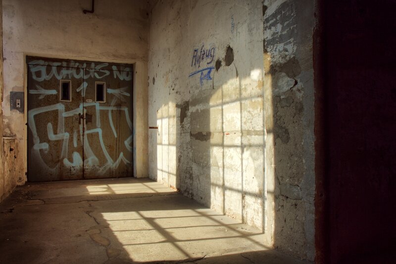 Sunlit corridor with graffiti