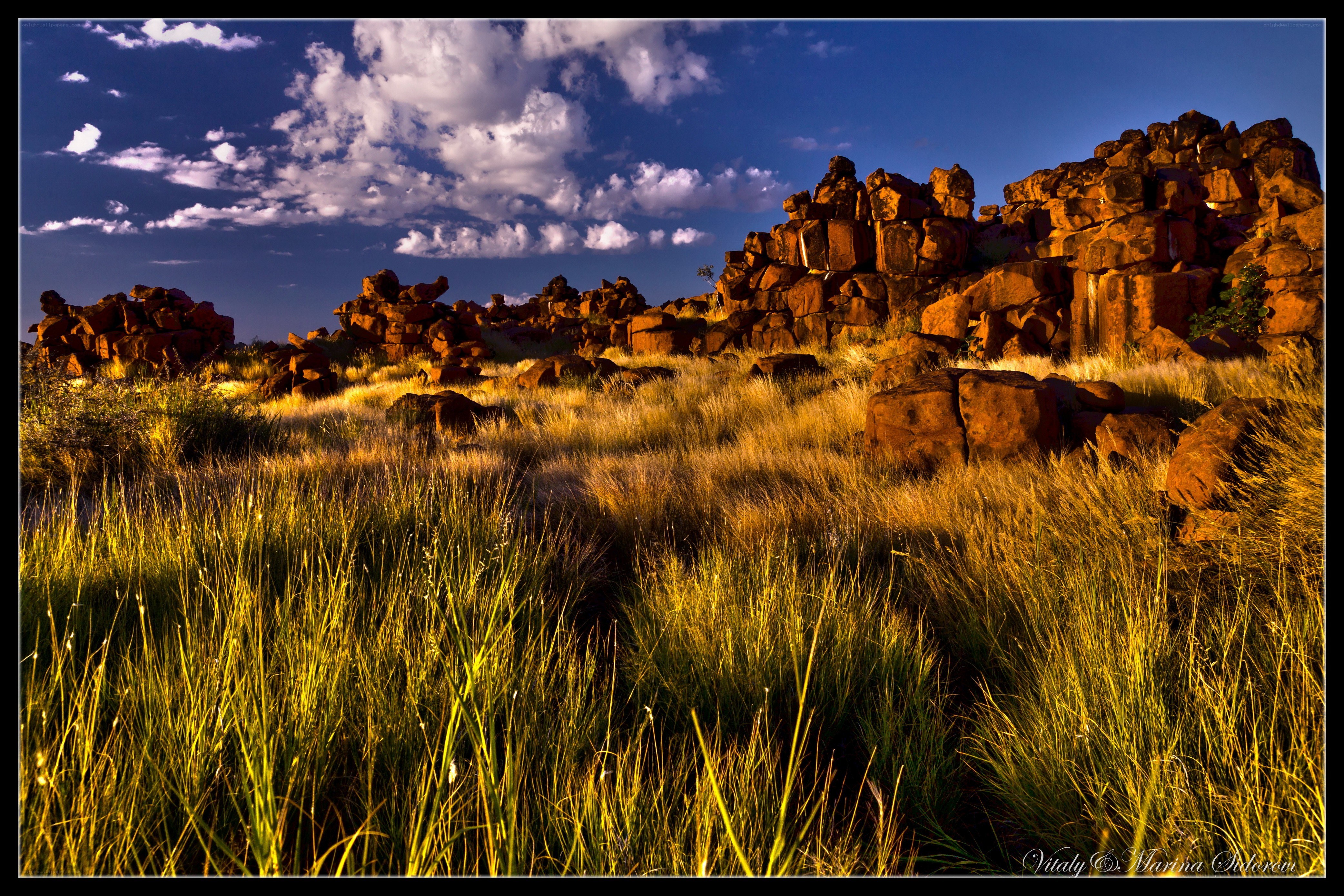 Sunlit grassland with rock formations