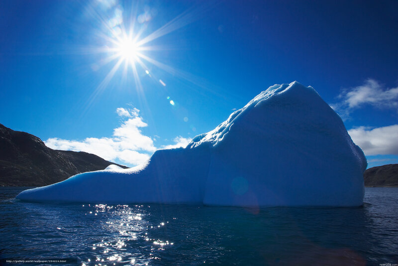 Sunlit iceberg in blue water
