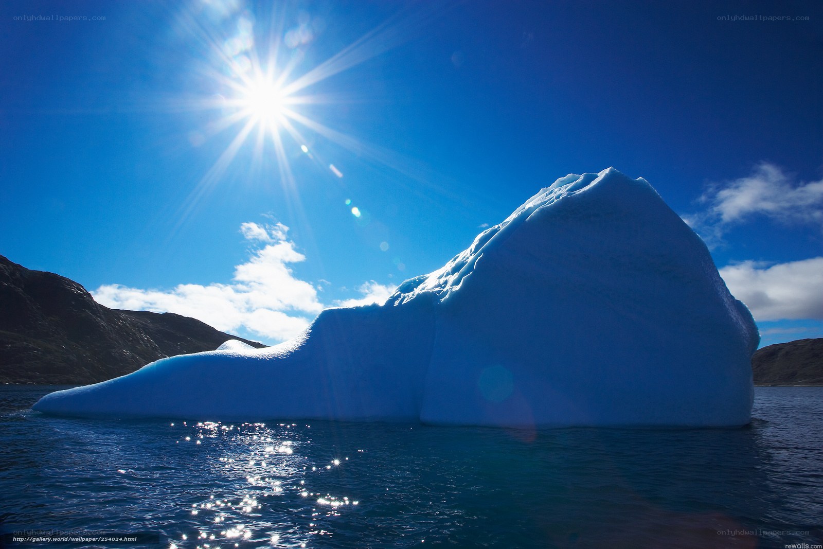 Sunlit iceberg in blue water