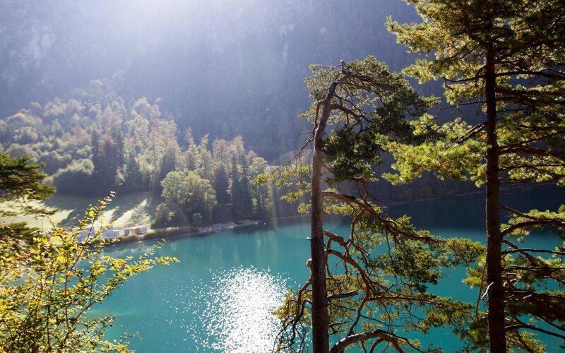 Sunlit lake in forested valley