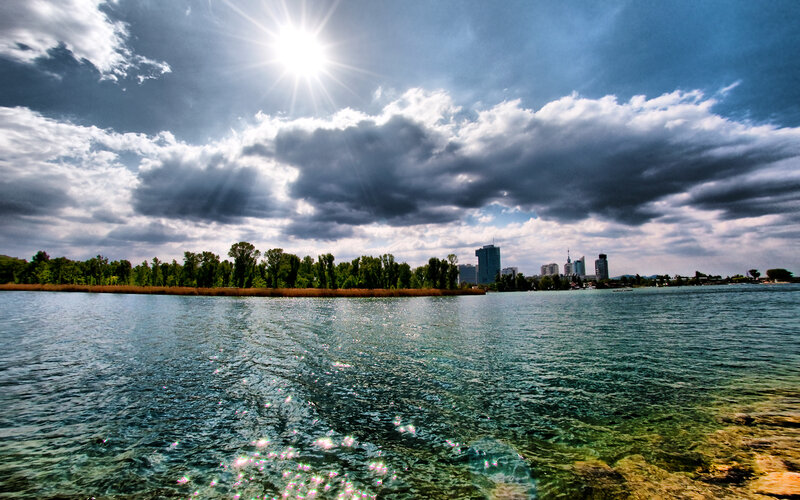 Sunlit lake with city skyline