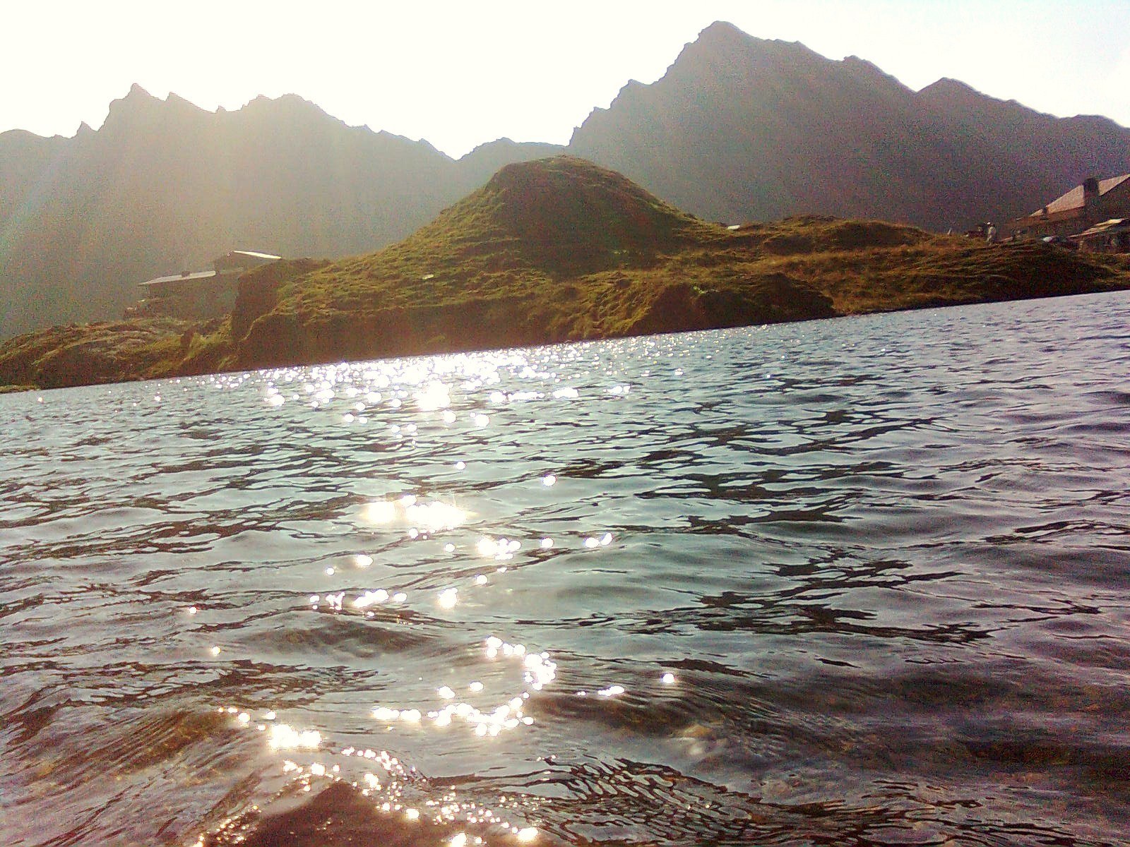 Sunlit lake with mountain backdrop