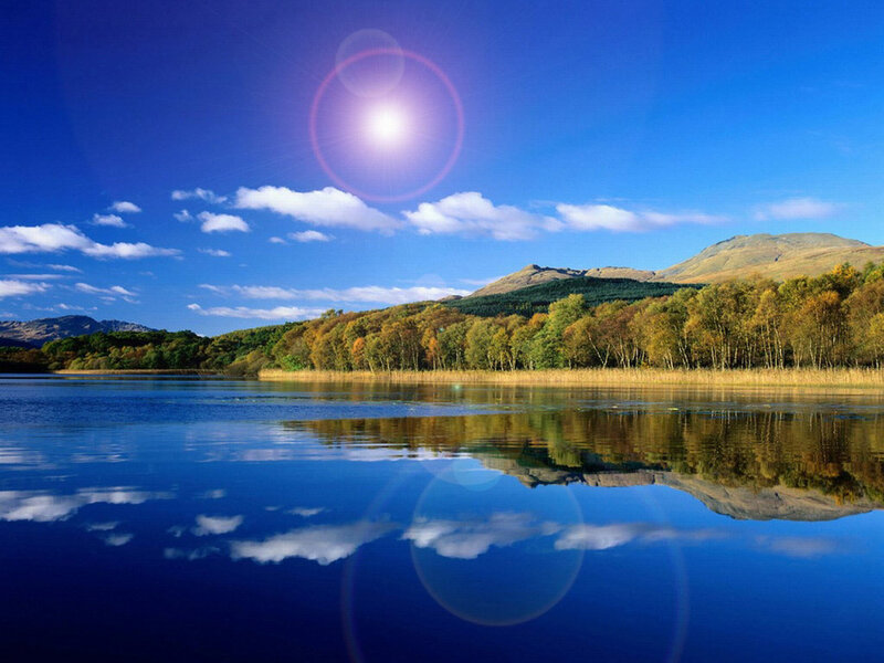 Sunlit lake with mountain reflection