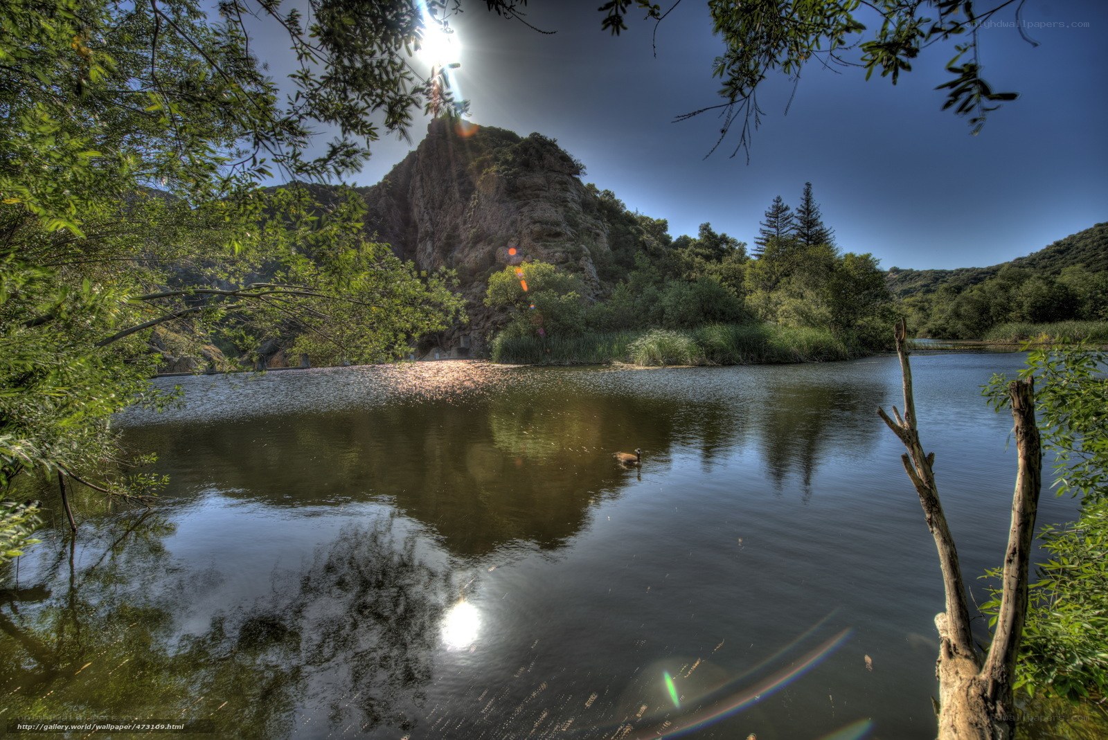 Sunlit lake with rocky hill