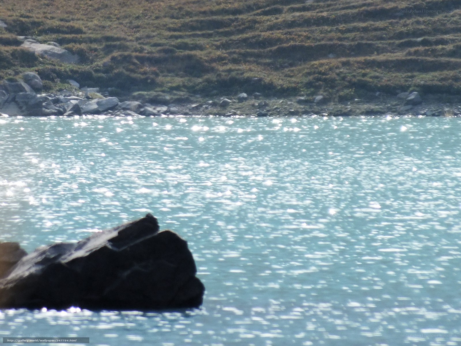 Sunlit lake with rocky shore