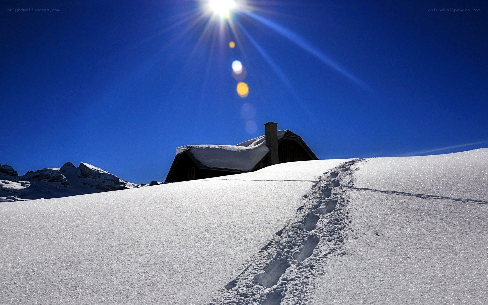 Sunlit mountain cabin in snow