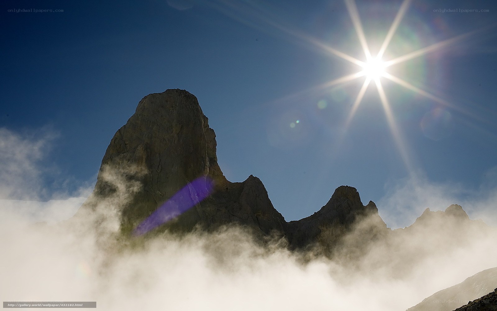 Sunlit mountain peak above clouds