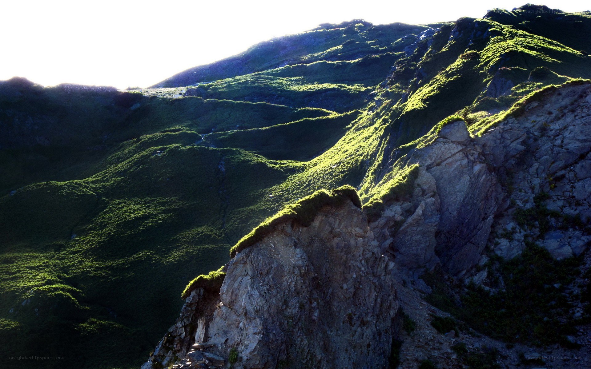 Sunlit mountain ridge with green slopes