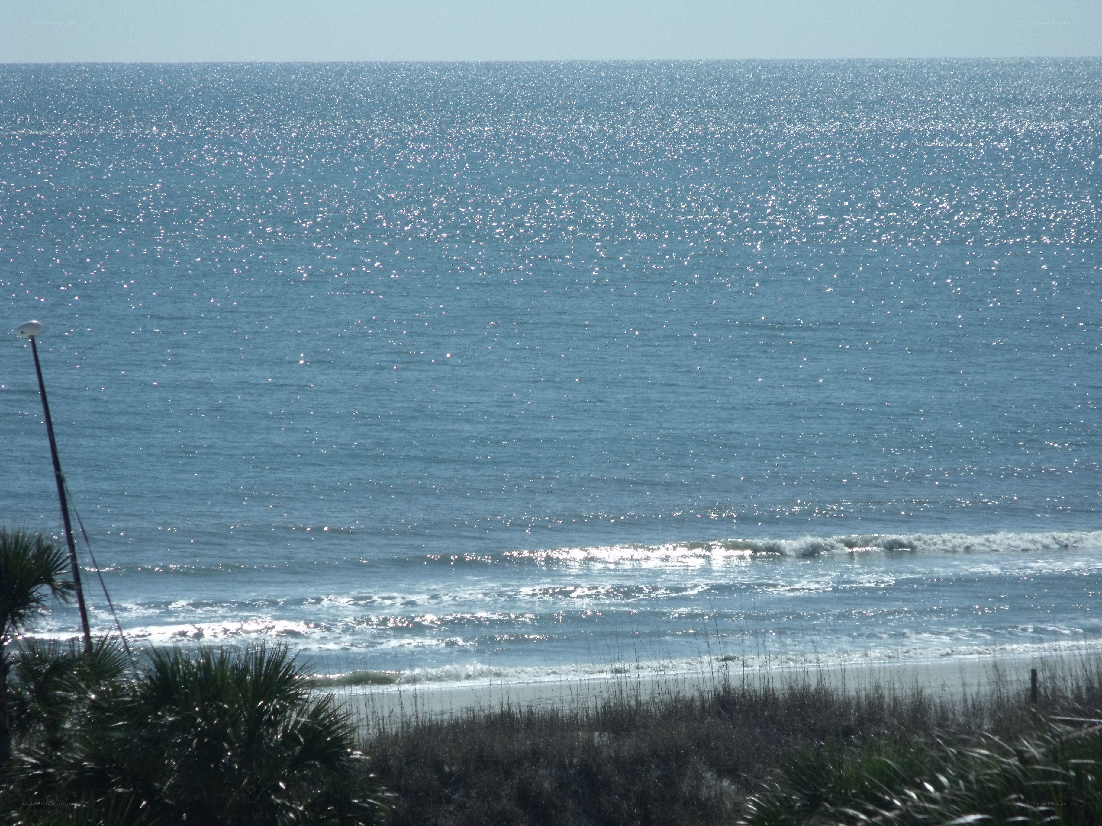 Sunlit ocean waves at beach