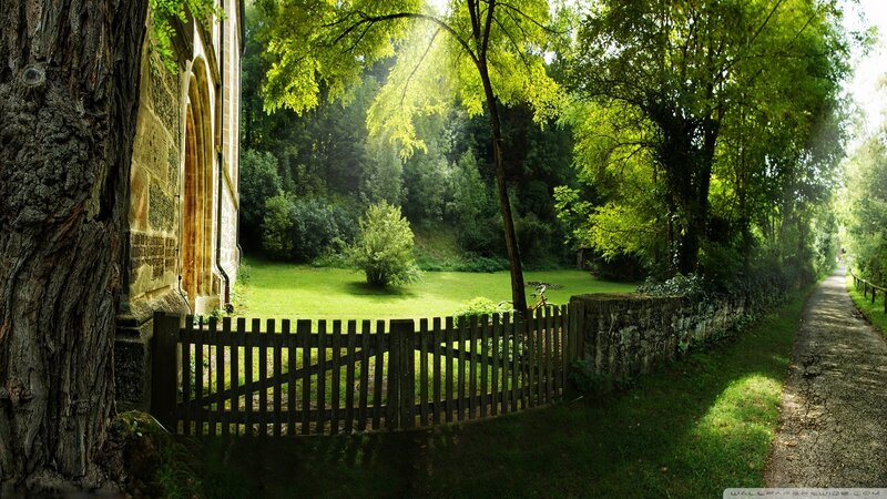 Sunlit path by old stone building
