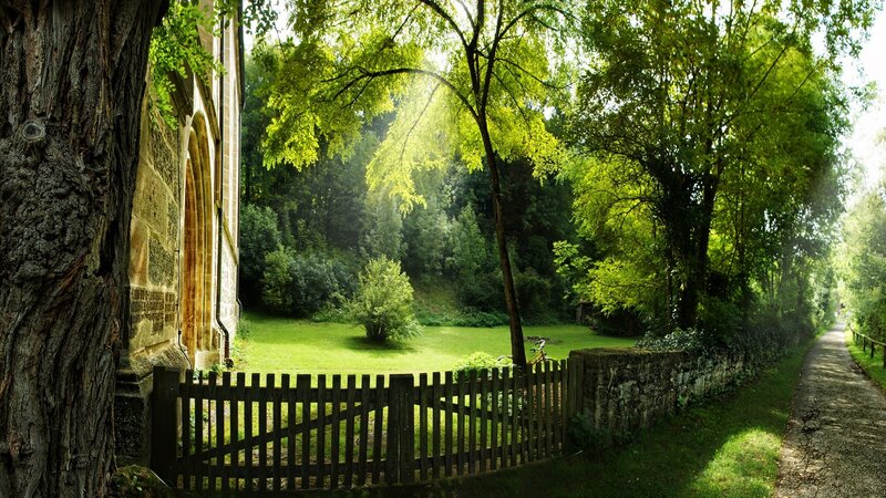 Sunlit path by old stone building