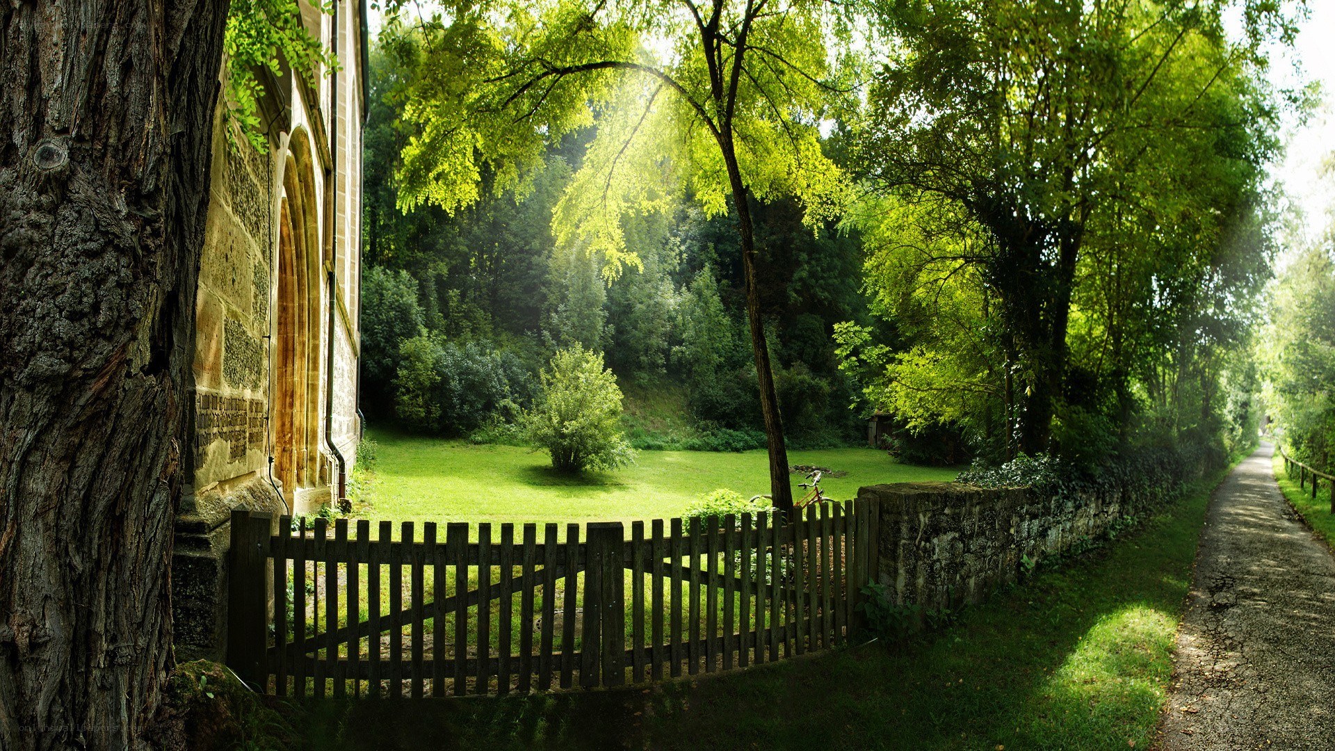 Sunlit path by old stone building