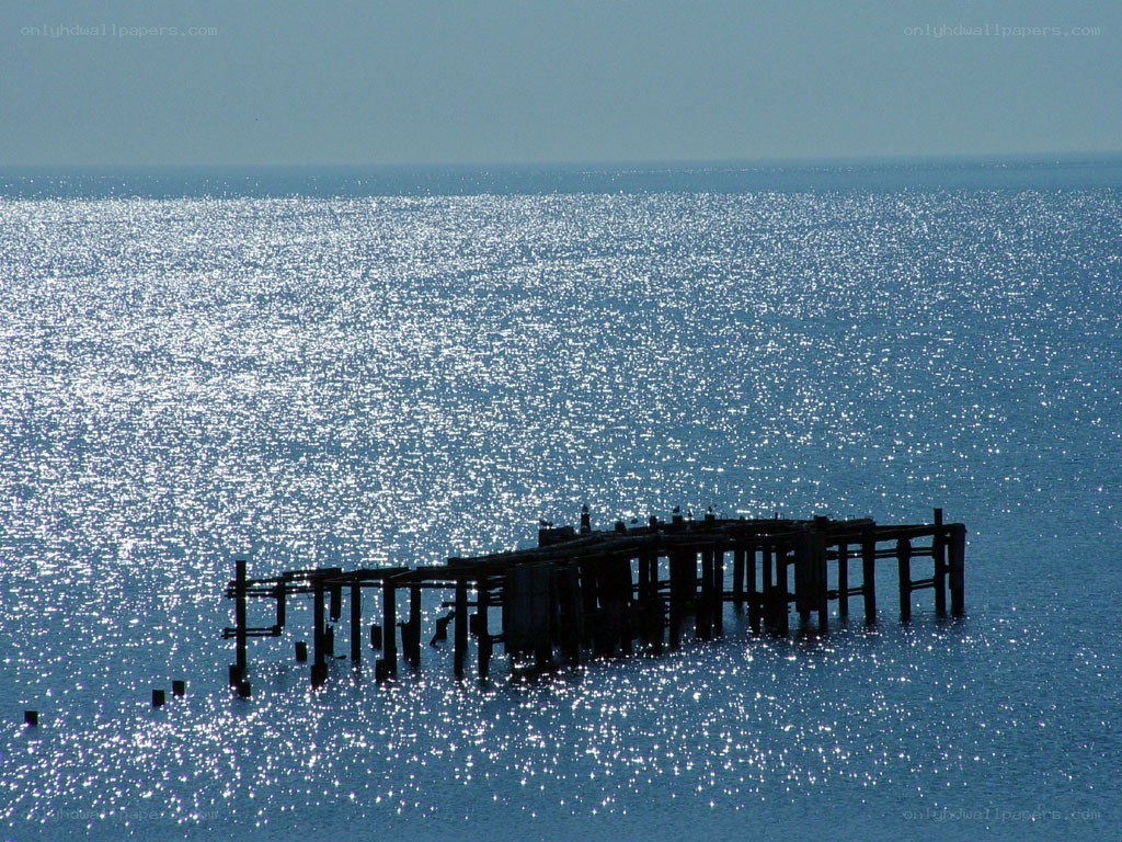 Sunlit pier on calm sea