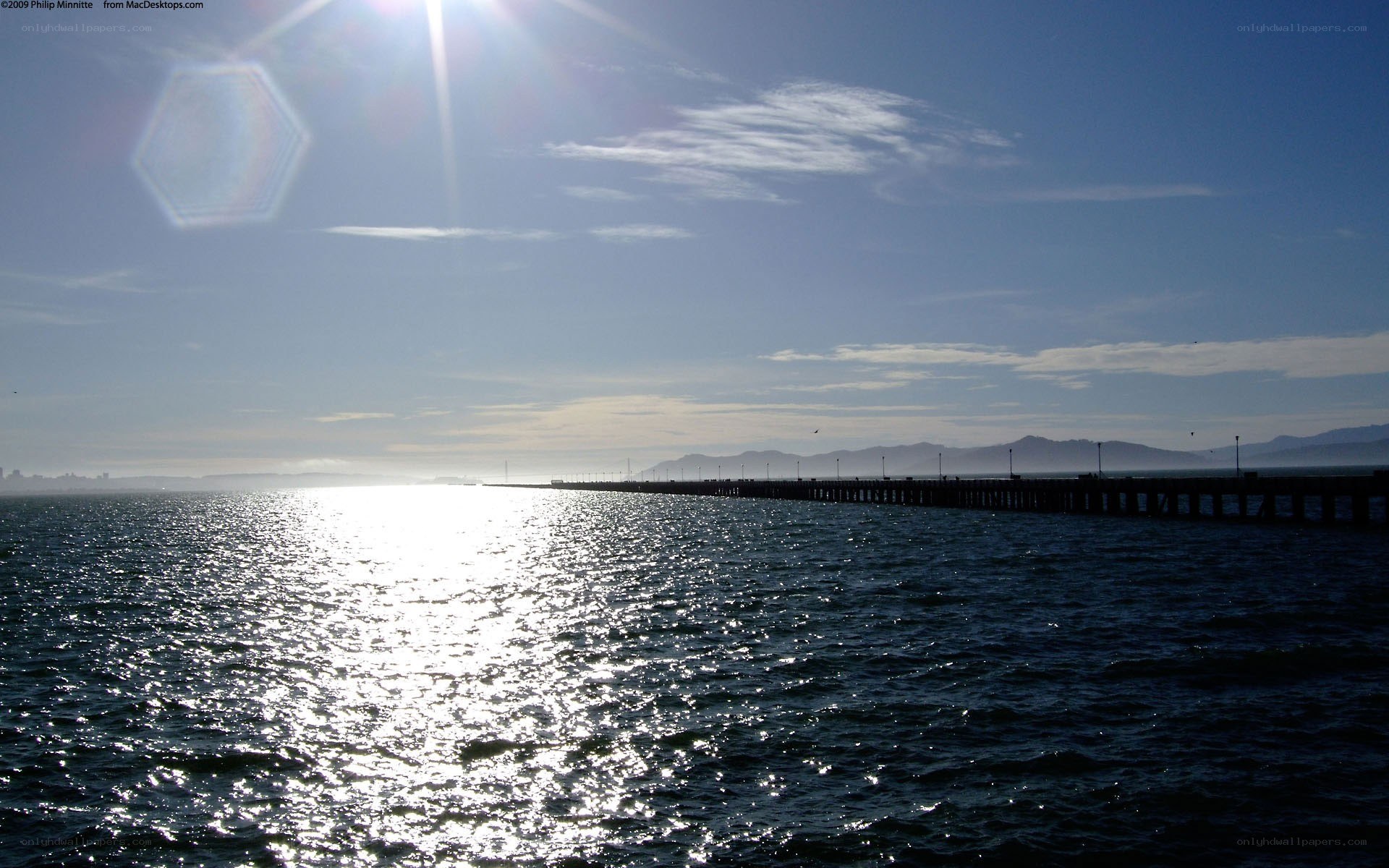 Sunlit pier over calm water