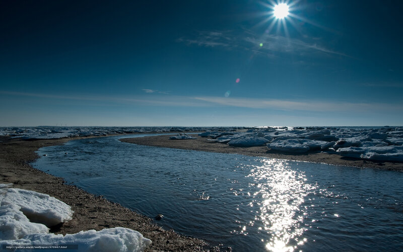 Sunlit river with ice floes