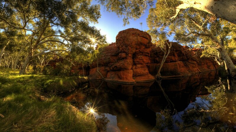 Sunlit river with red rock formations