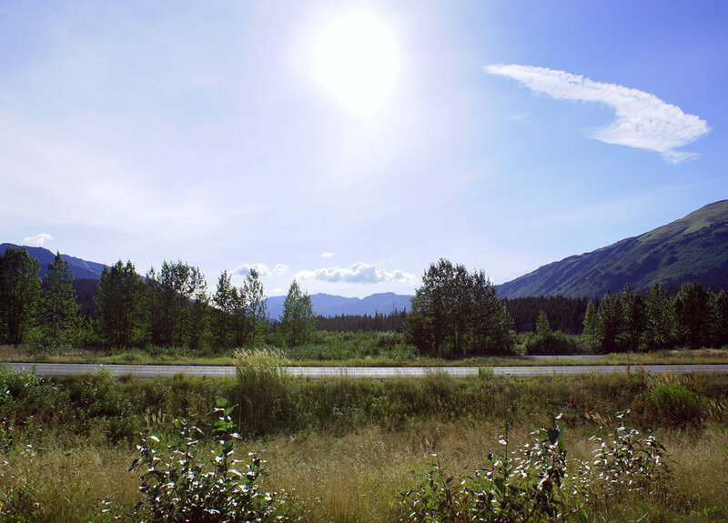 Sunlit road through mountain valley