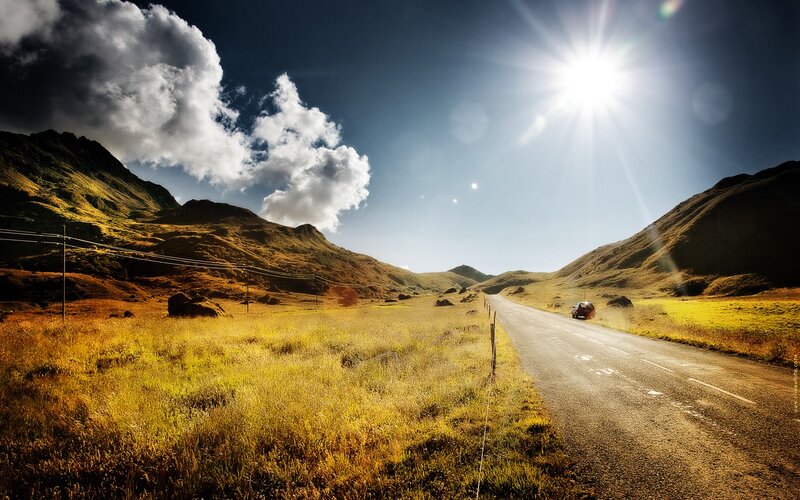 Sunlit road through mountain valley