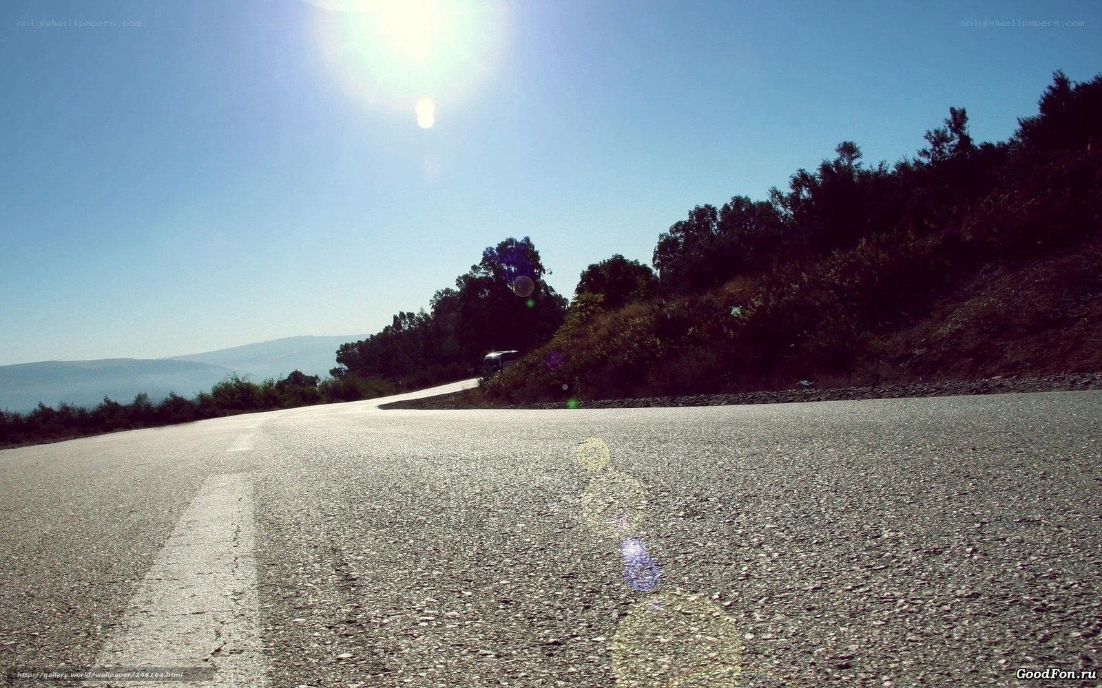Sunlit road winding through hills