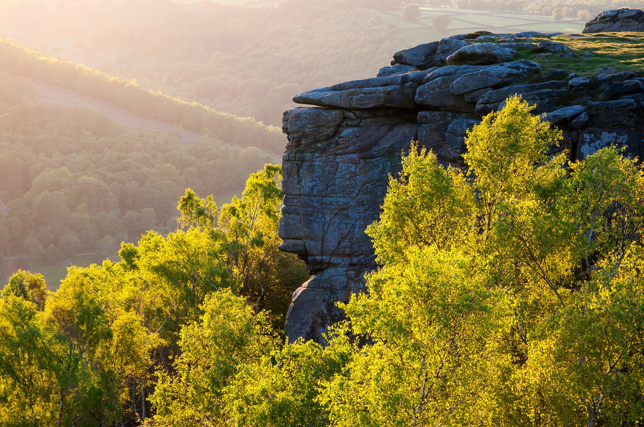 Sunlit rock formation in valley