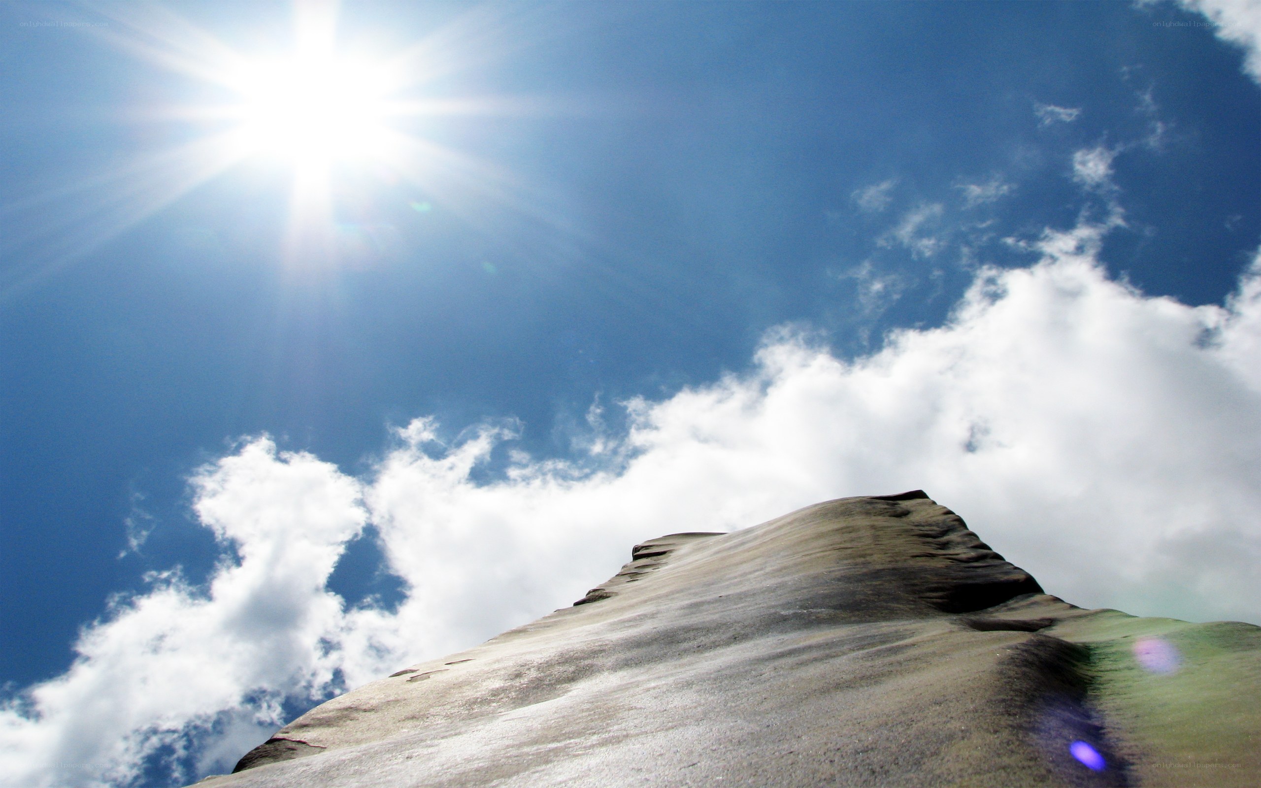 Sunlit rock formation under blue sky