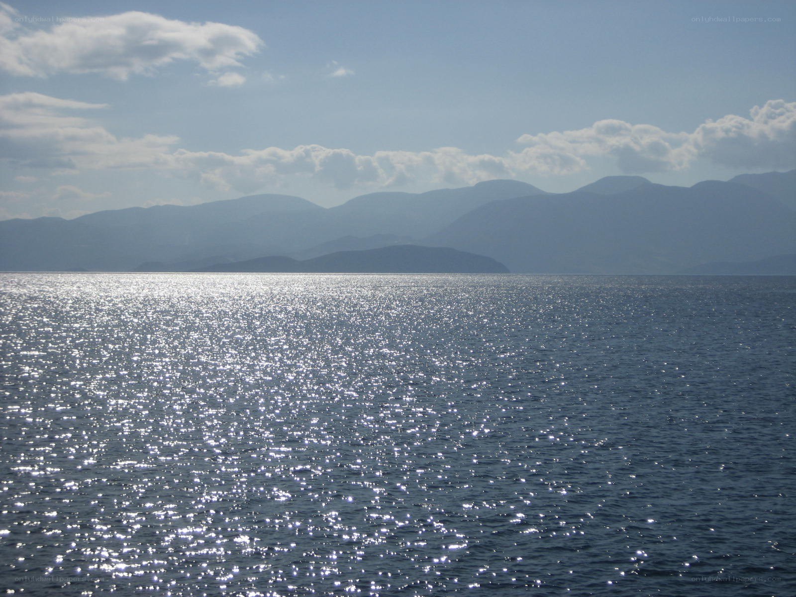 Sunlit sea with distant mountains