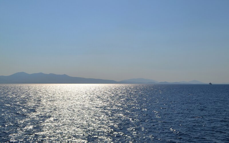 Sunlit sea with distant mountains