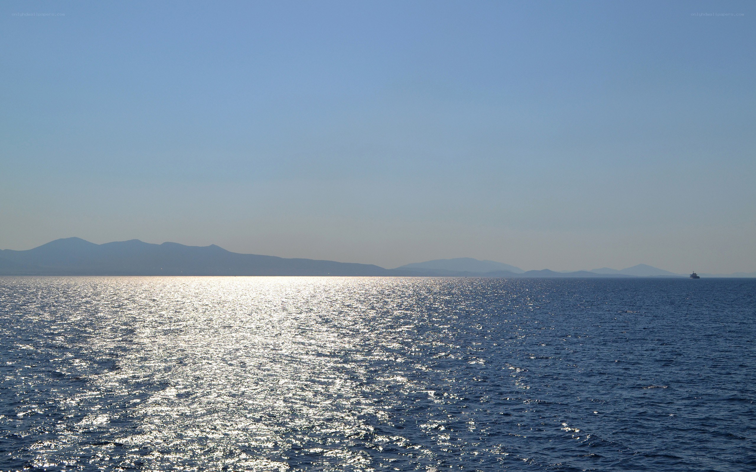 Sunlit sea with distant mountains