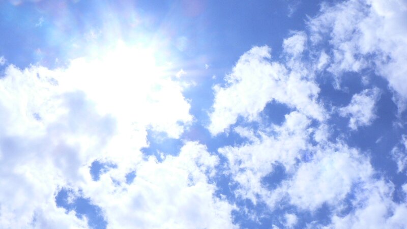 Sunlit sky with fluffy clouds