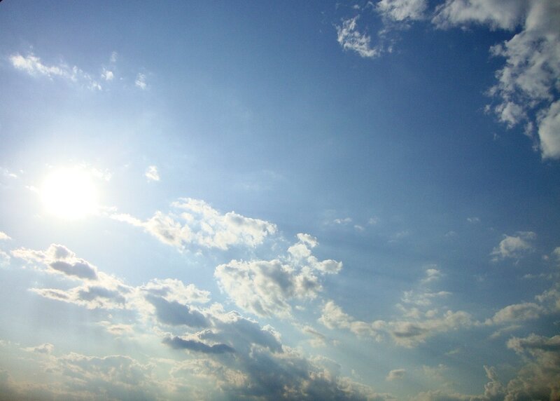 Sunlit sky with scattered clouds