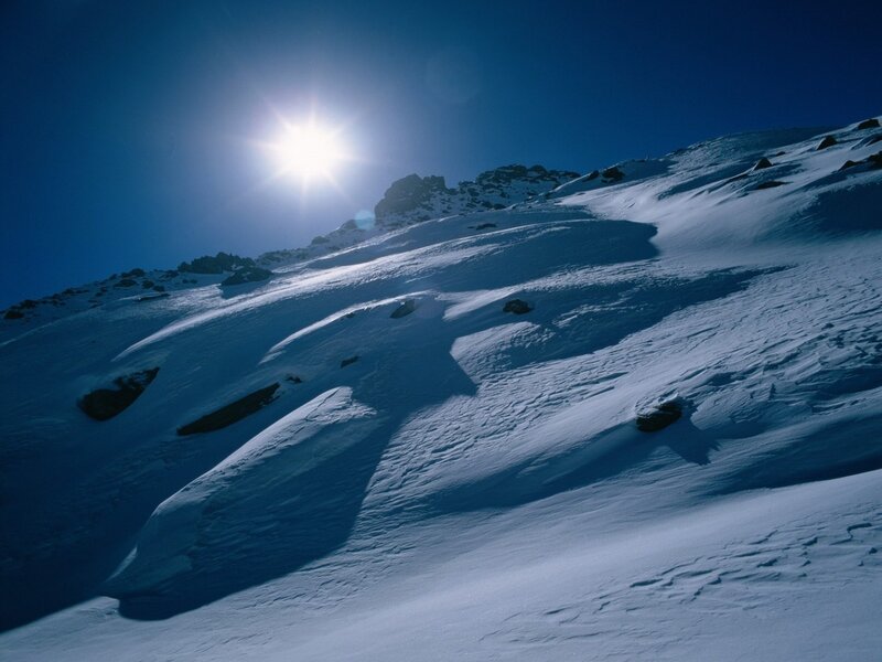 Sunlit snow-covered mountain slope