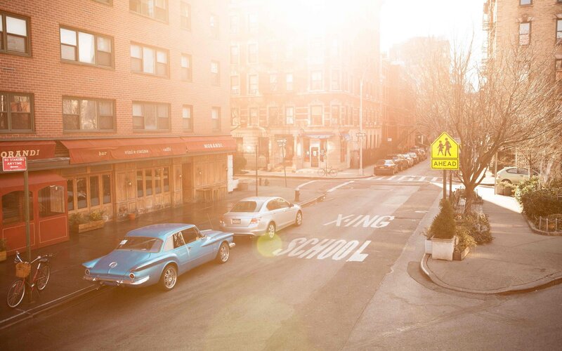 Sunlit street with classic cars