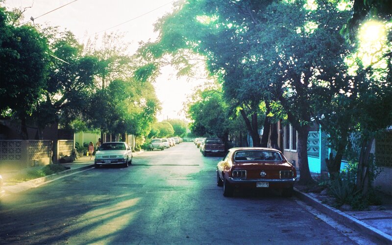 Sunlit street with vintage cars