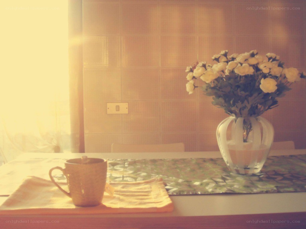 Sunlit table with flowers and mug
