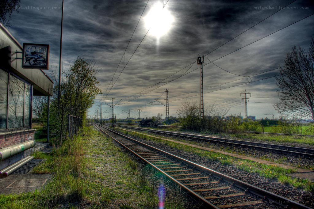Sunlit train tracks at a quiet station