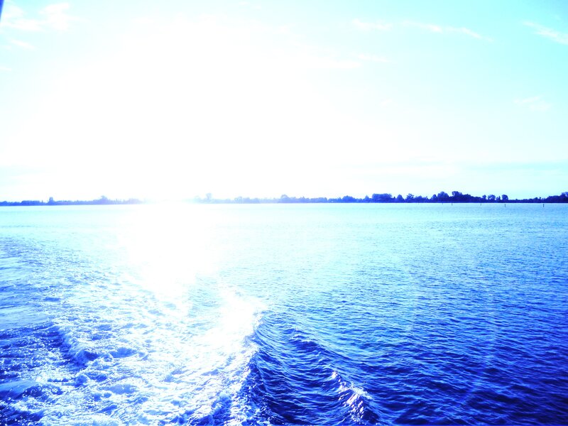 Sunlit water trail from a boat
