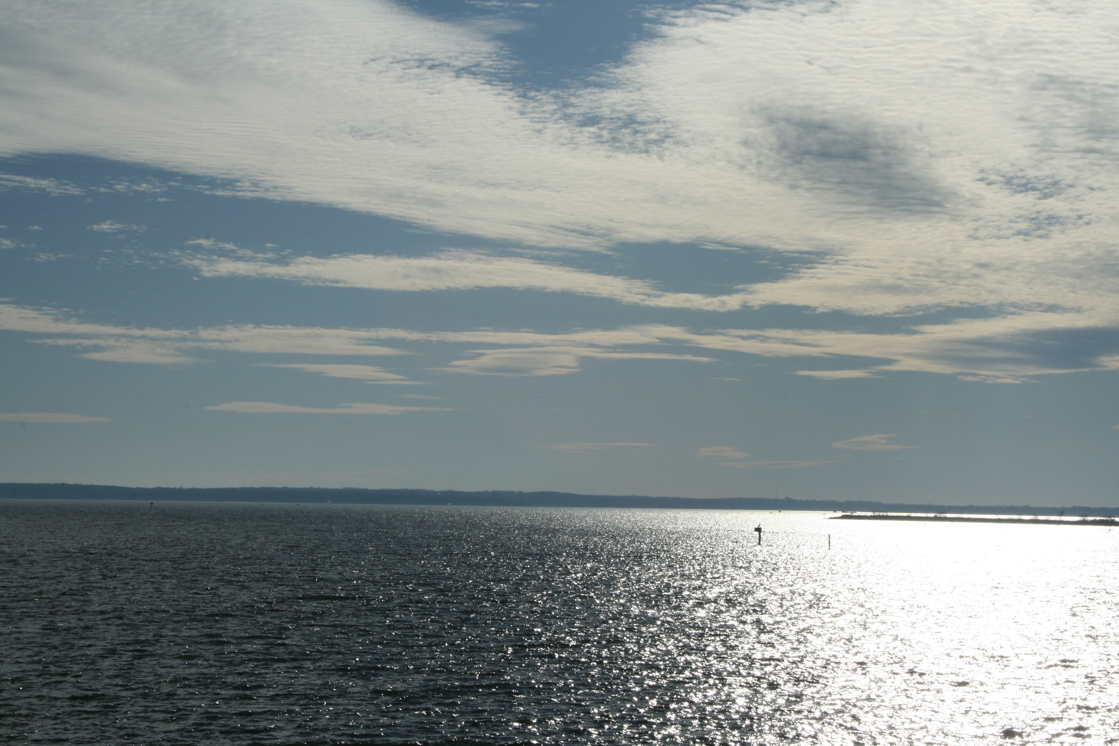 Sunlit water with scattered clouds