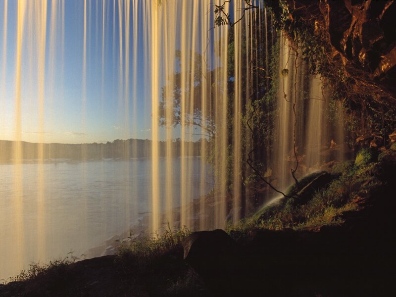 Sunlit waterfall at river