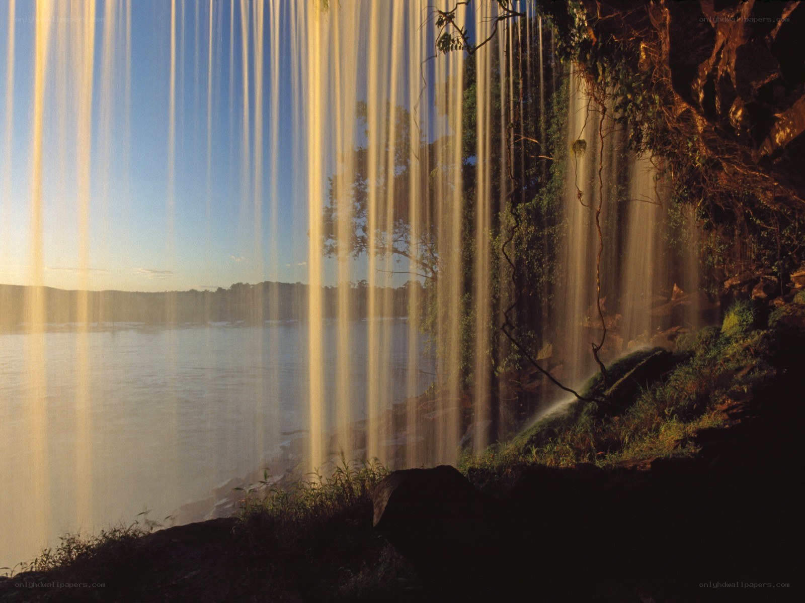 Sunlit waterfall at river
