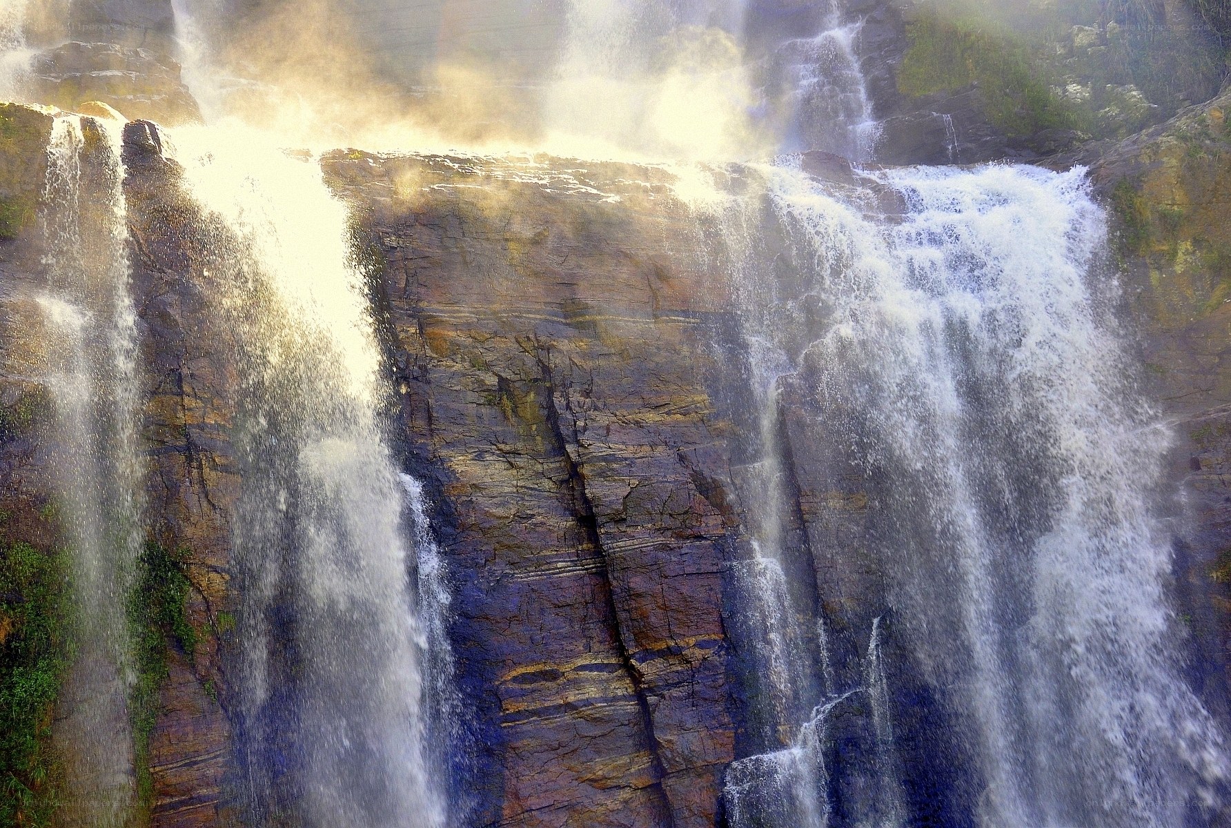 Sunlit waterfall cascading over rocks