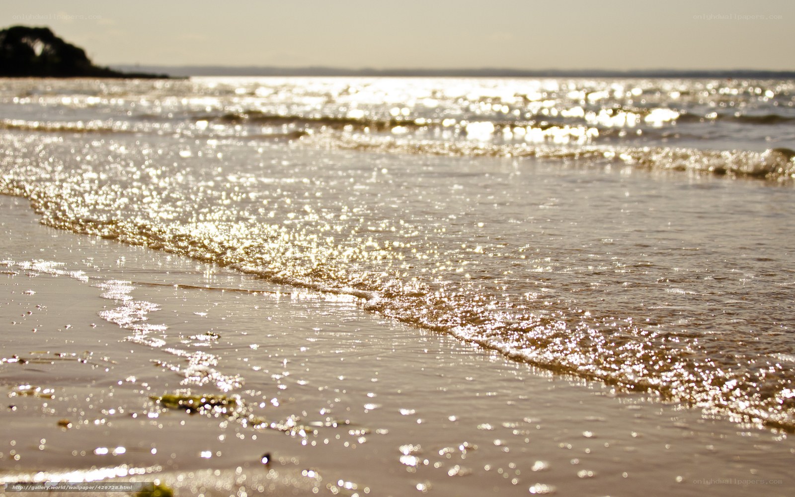 Sunlit waves on a sandy beach