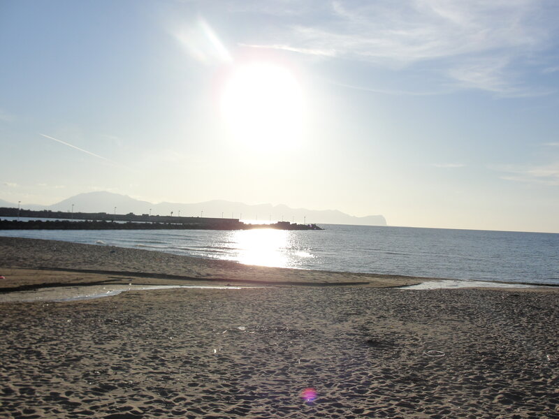sunny beach with distant mountains