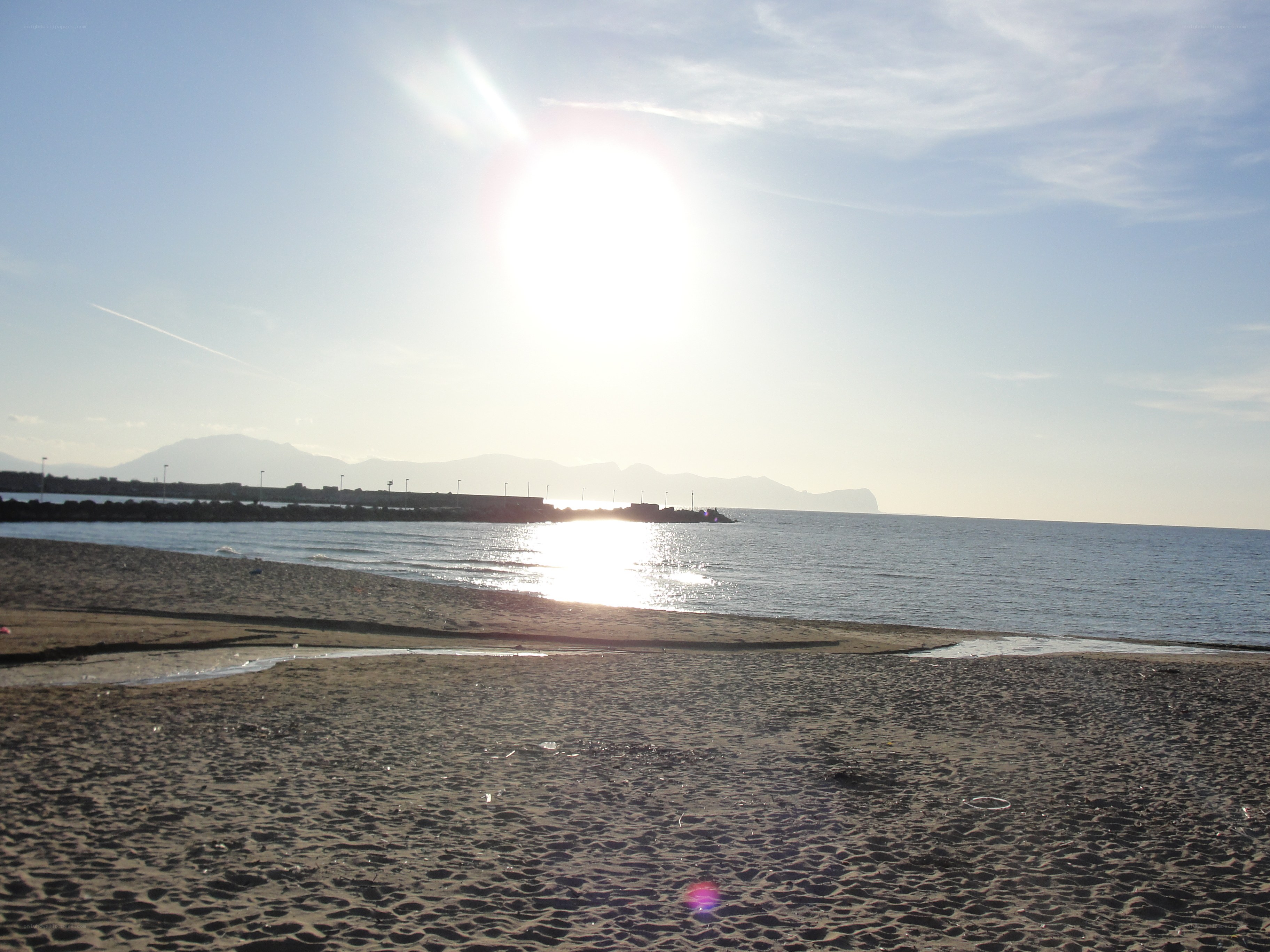 sunny beach with distant mountains