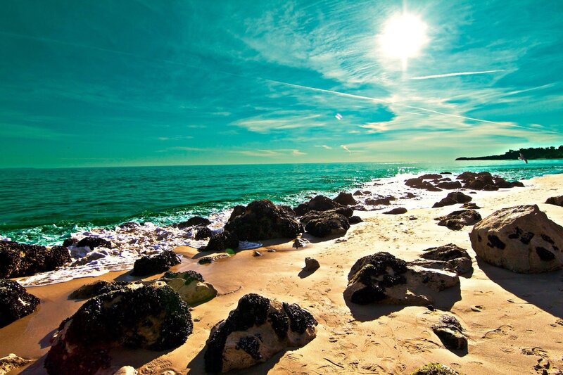 Sunny beach with rocks and turquoise water