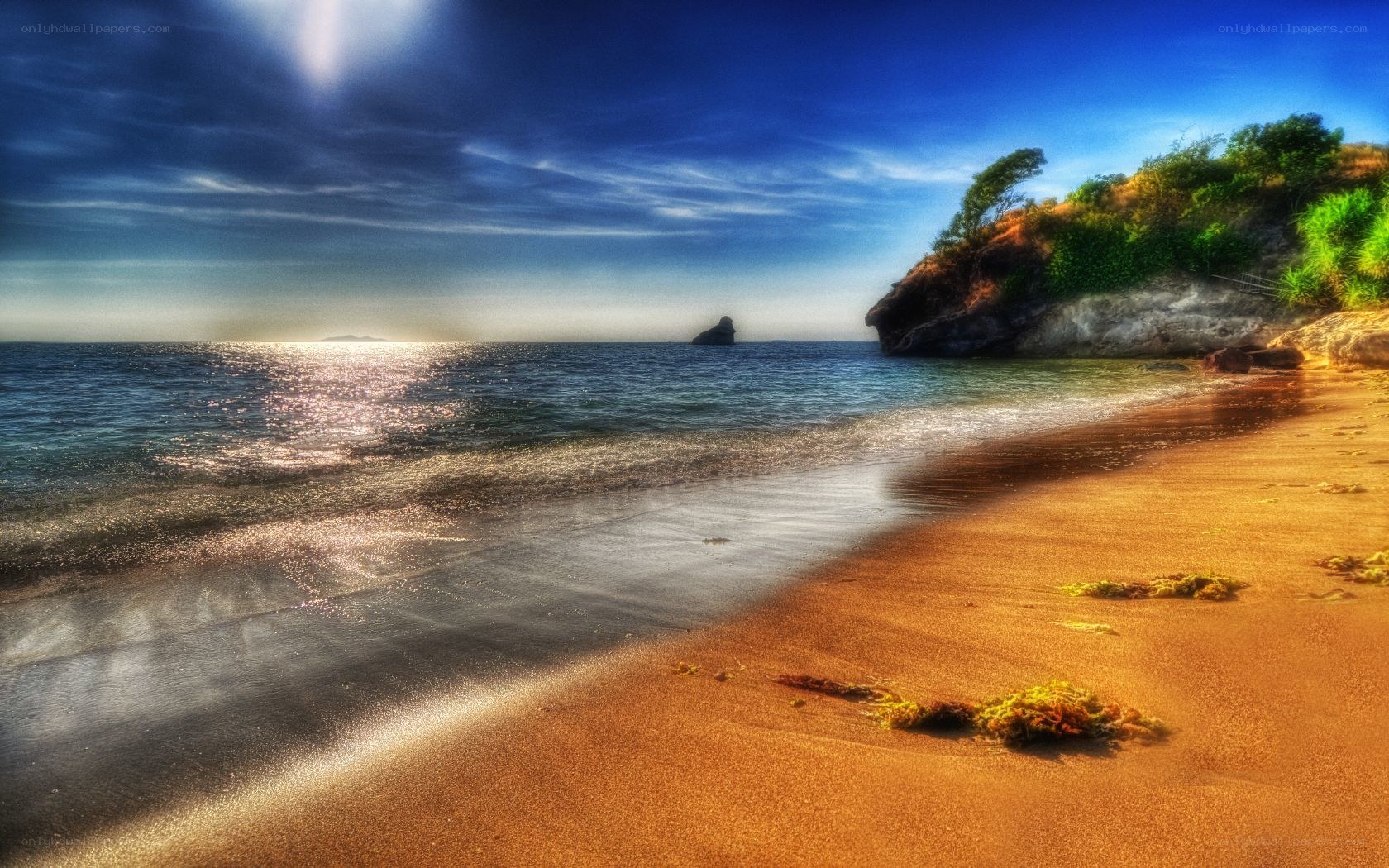 Sunny beach with rocky cliff